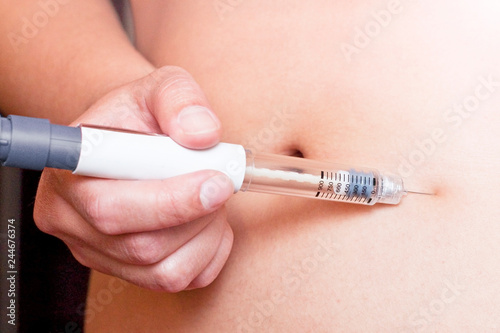 Woman is injecting hormones by single use syringe pen with dose. Ectrocorporal conception, Diabetes concept.