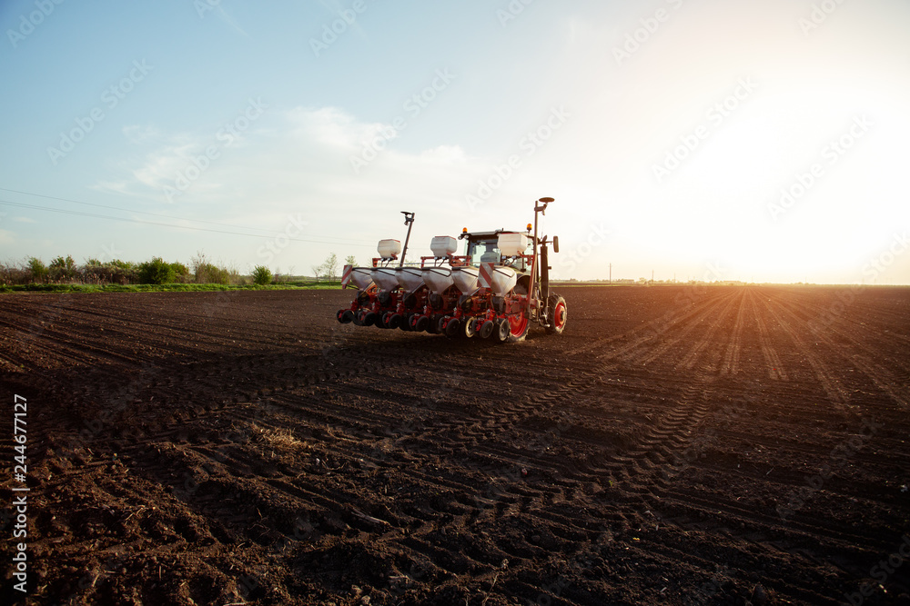 Farmer sowing crops at field with tractor. - Image Farmer sowing crops at field with tractor. - Image