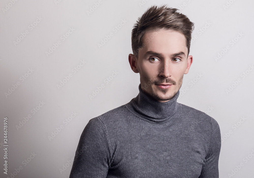 Handsome young elegant man in grey golf.