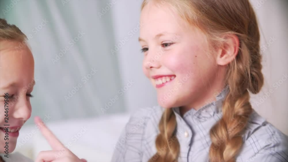 Portrait of two adorable playful girls with long braids smiling and having good time Portrait of two adorable playful girls with long braids smiling and having good time