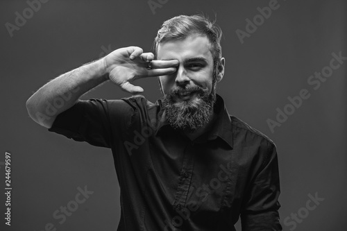 Stylish young red-haired man with a beard and mustache dressed i