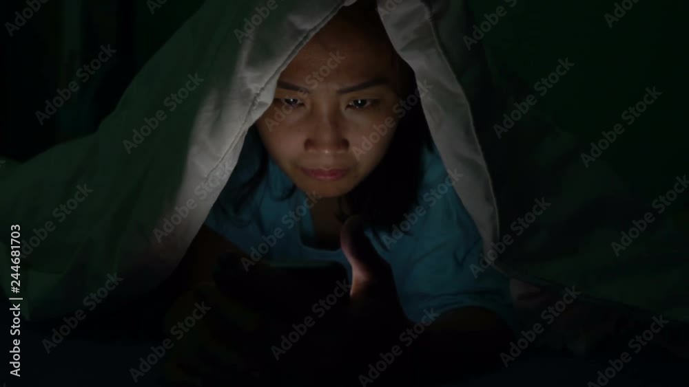 Asian woman play smartphone in the bed at night,Thailand people,Addict social media,Play internet all night,Lychnobite Asian woman play smartphone in the bed at night,Thailand people,Addict social media,Play internet all night,Lychnobite