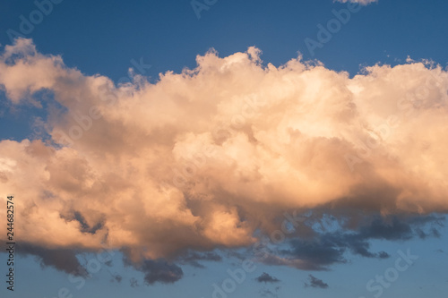 White clouds in summer blue sky at golden hour photo