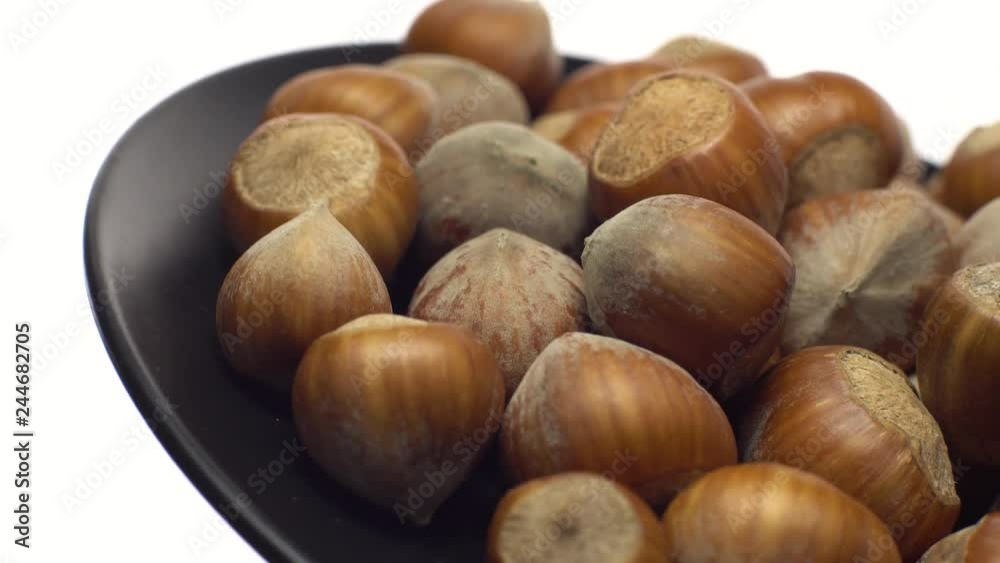 Hazel nuts in nutshell. Rotation. Closeup. Walnuts in a bowl. Selective focus. Isolated on white. Studio shot. Healthy food concept. Hazel nuts in nutshell. Rotation. Closeup. Walnuts in a bowl. Selective focus. Isolated on white. Studio shot. Healthy food concept.