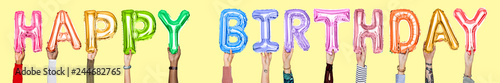 Hands holding Happy Birthday word in balloon letters