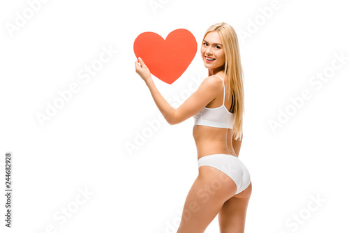 beautiful smiling girl in underwear holding heart shaped card isolated on white
