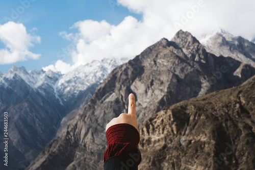 Feminine hand pointing at the mountains photo