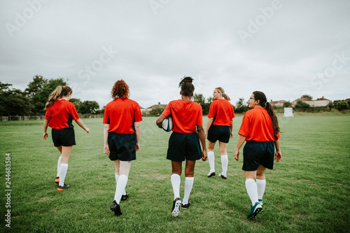 Female rugby players walking on the field