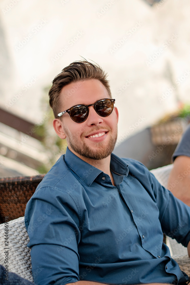 young handsome man in sunglasses smiling young handsome man in sunglasses smiling