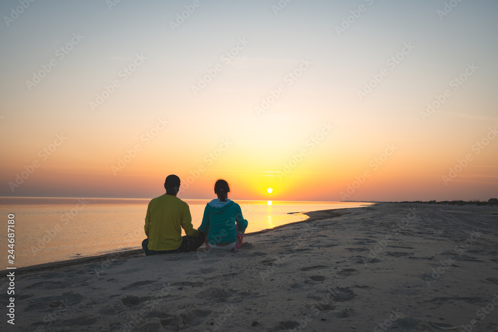 Romantic couple of travelers is sitting on the beach