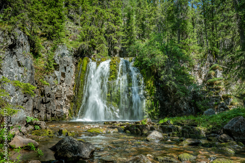 Fototapeta Naklejka Na Ścianę i Meble -  Waterfall flushing down a green moss covered rock wall