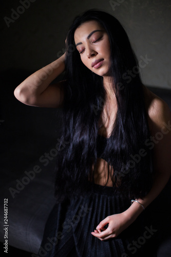 lowkey portrait of beautiful woman with closed eyes over dark background