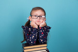 happy child little girl with glasses reading a books