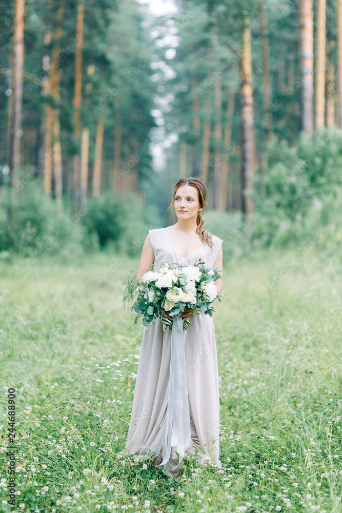Boudoir photo shoot of the bride in the woods with a bouquet. Flying dress and beautiful girl in the Park. Boudoir photo shoot of the bride in the woods with a bouquet. Flying dress and beautiful girl in the Park.
