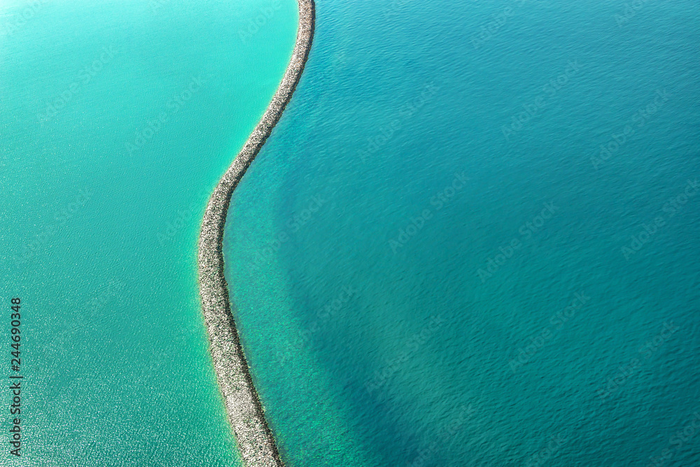 Obraz premium Widok z lotu ptaka na zaporę w wodzie w pobliżu wybrzeża Dubaju