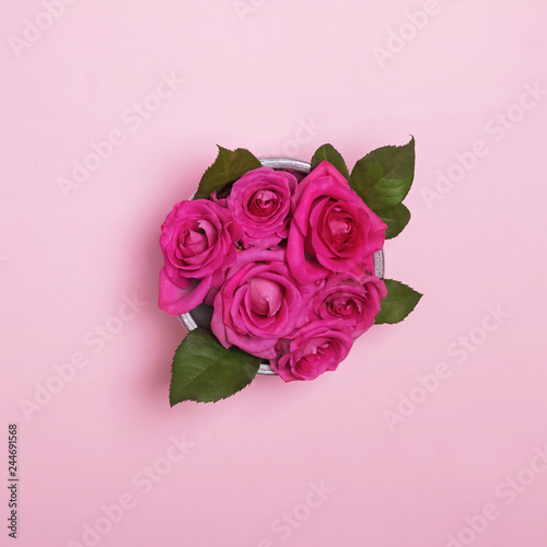 Beautiful roses bouquet in a bowl on the pink background