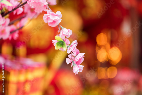 beautiful lifelike ornamental fake peach flowers in front of  traditional red Chinese lanterns (Chinese New Year or Spring Festival concept) photo