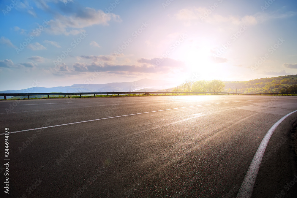 Fototapeta premium empty asphalt highway road bend and sunset sky