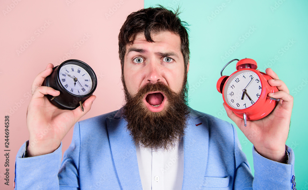 Man Changing Time Does changing clock mess with your health. Man bearded hipster hold two ...