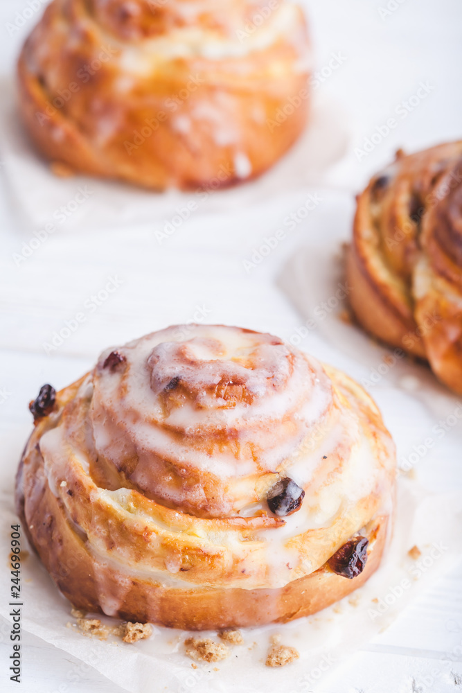 Fototapeta premium Cinnamon rolls buns on a white marble wooden background. Bakery concept. Breakfast and brunch. Flatlay. Minimalistic photo. Overhead. Copy space
