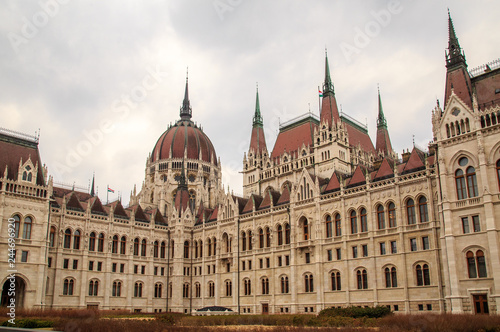 Daytime view of historical building of Hungarian Parliament, aka Orszaghaz, with typical symmetrical architecture and central dome on Danube River embankment in Budapest, Hungary, Europe