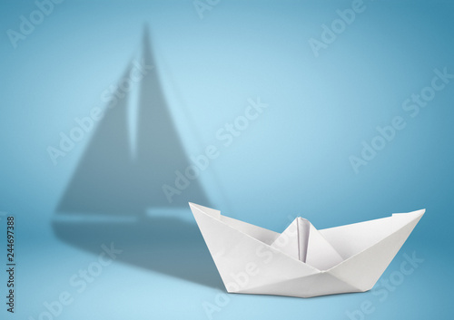 Sailing yacht concept, paper ship with sailing boat shadow