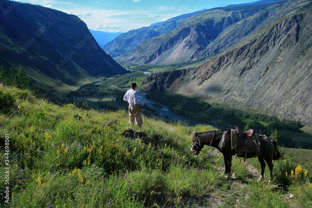 Beautiful view of the Valley of Chulyshman river and a man with a horse on Altai in Russia
