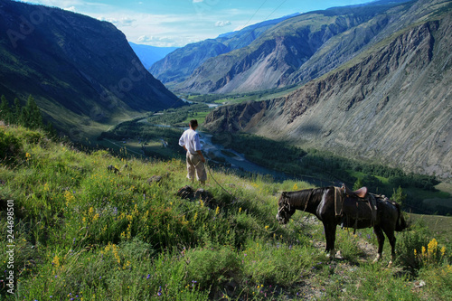 Beautiful view of the Valley of Chulyshman river and a man with a horse on Altai in Russia © yanakoroleva27
