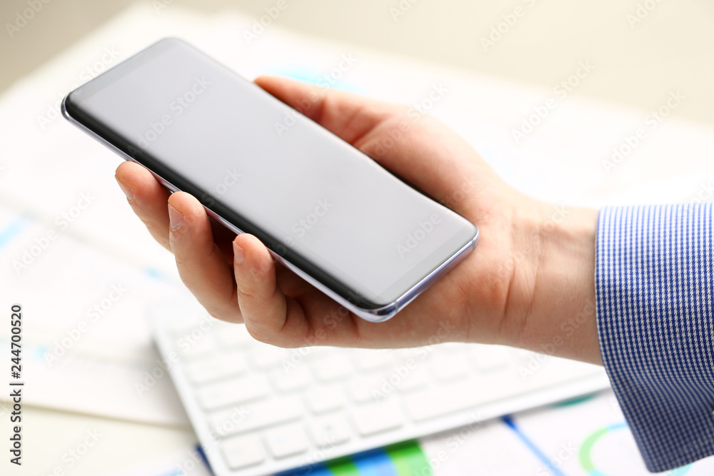 Businessman arm using modern cell phone closeup Businessman arm using modern cell phone closeup