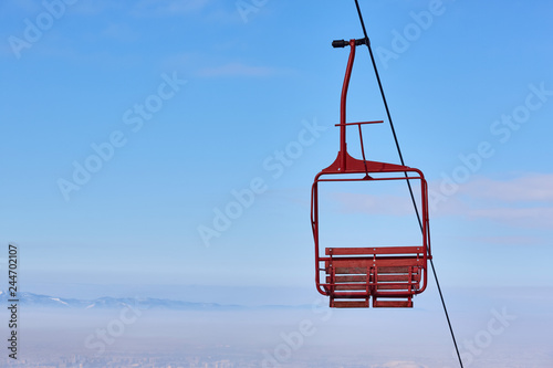 Empty old wooden chairlift against blue sky. Brasov, Romania. photo