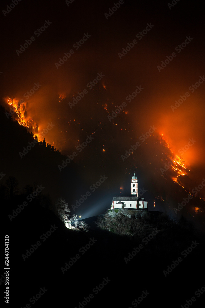 Church of Soazza and forest on fire