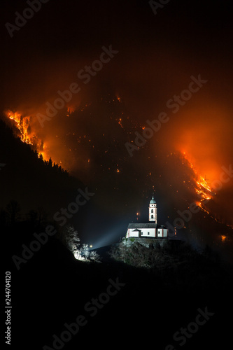 Church of Soazza and forest on fire