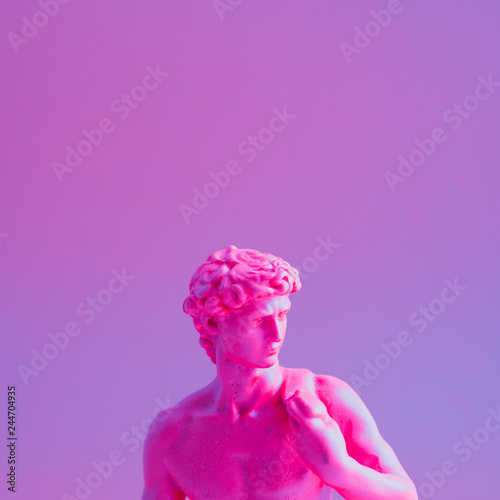 Creative concept of purple neon David is a masterpiece of Renaissance sculpture created  by Michelangelo. Vaporwave style  . photo