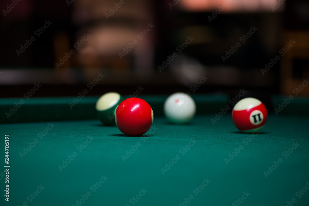 Sport billiard balls on green billiard table in pub. On going billiard game. Competitive players trying to find out the winner of the round Sport billiard balls on green billiard table in pub. On going billiard game. Competitive players trying to find out the winner of the round