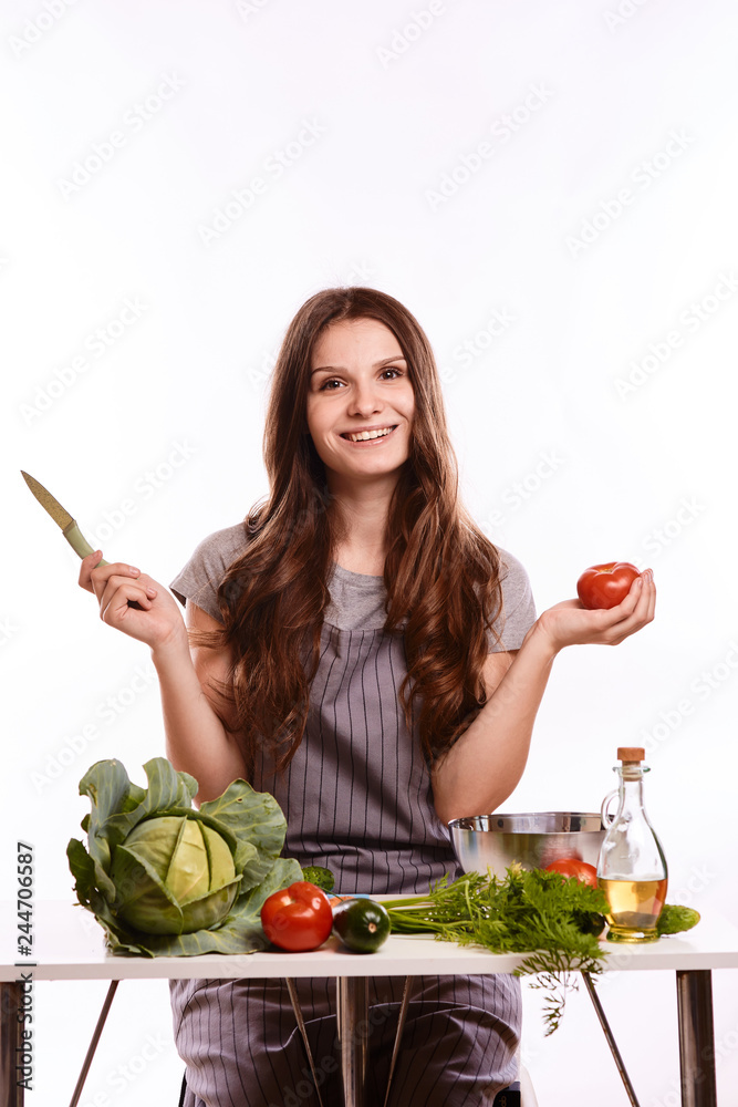 happy adult woman with various fresh vegetables on kitchen table looking at camera happy adult woman with various fresh vegetables on kitchen table looking at camera