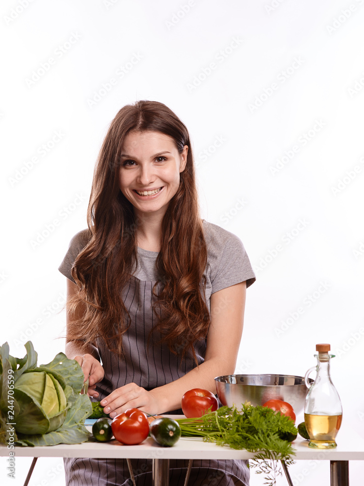 happy adult woman with various fresh vegetables on kitchen table looking at camera happy adult woman with various fresh vegetables on kitchen table looking at camera