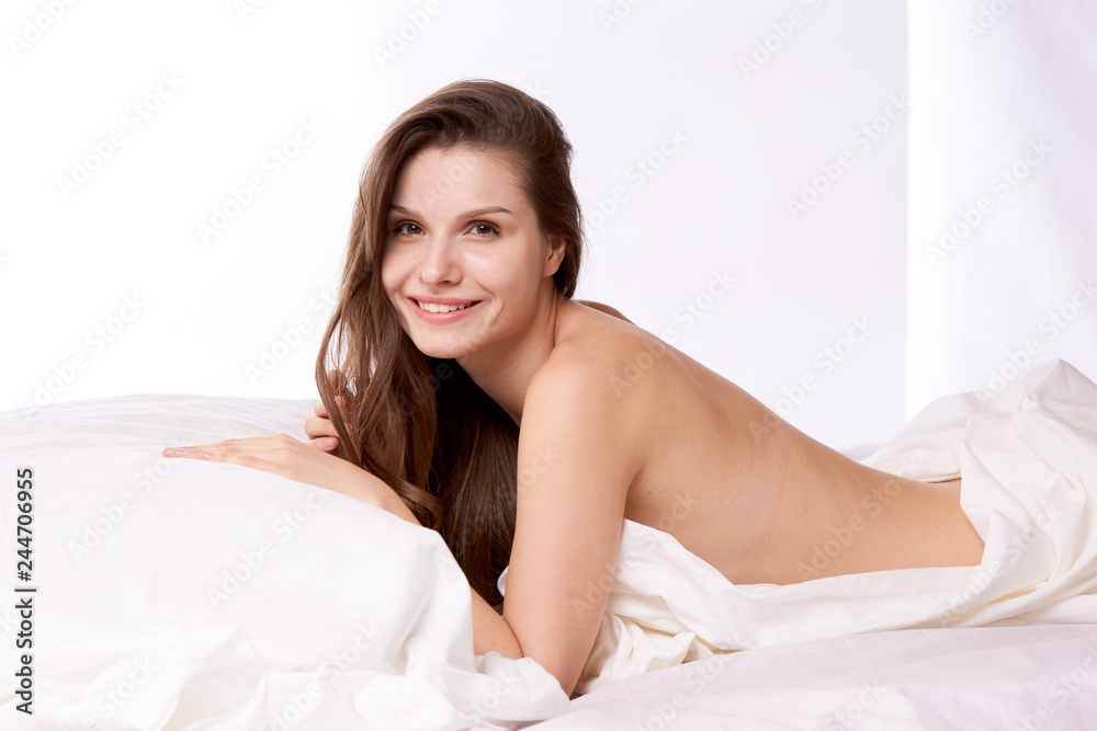 brunette woman lying on bed in bedroom