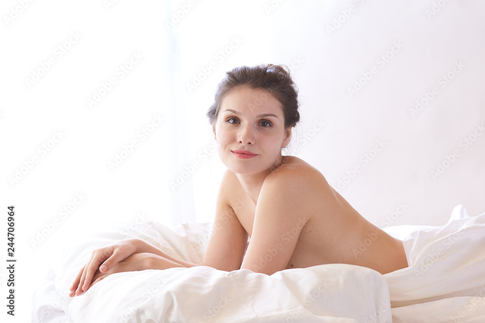 Obraz premium brunette woman lying on bed in bedroom