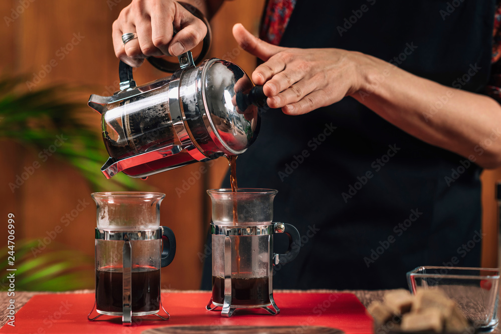 French Press Coffee. Barista Pouring French Press Coffee