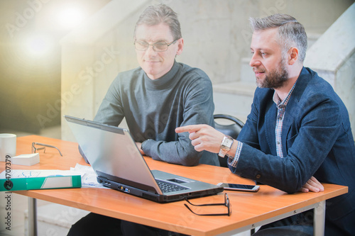 two colleagues sitting in the office at the laptop