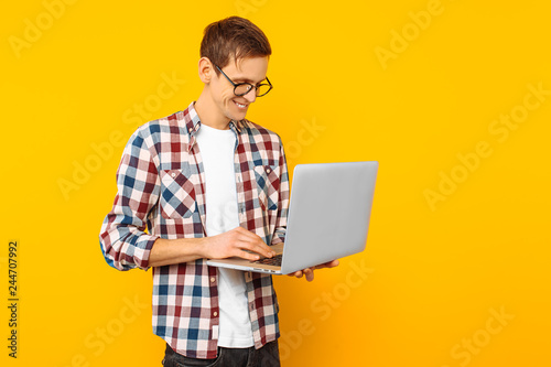 the man in glasses with a laptop, on a yellow background