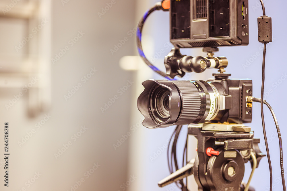 Professional film camera on a tripod in broadcasting studio