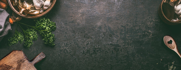 Abstract food background. Top view of dark rustic kitchen table with wooden cutting board and cooking spoon, frame. Banner or template with copy space for your design. Kitchen utensils objects