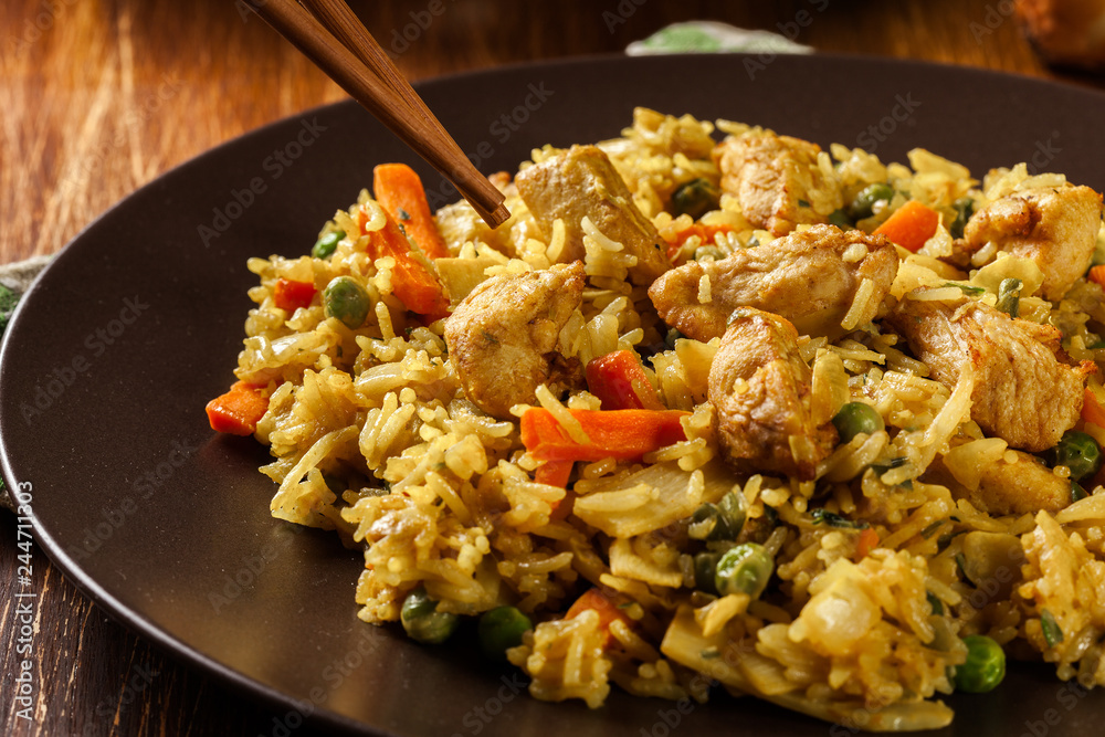 Fried rice nasi goreng with chicken and vegetables on a plate Fried rice nasi goreng with chicken and vegetables on a plate