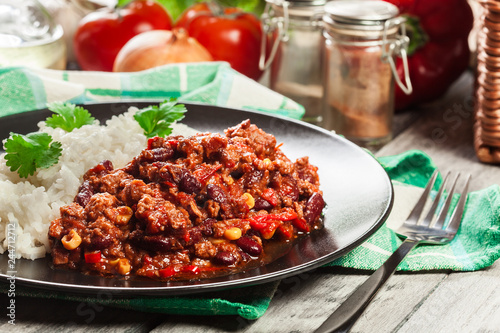 Hot chili con carne with ground beef, beans, tomatoes and corn served with rice
