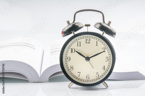 Clock and book with white background.