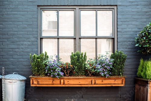 Beautiful windows with flowers on a black facade house photo