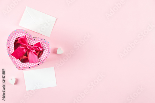 Happy Valentine's day concept. Close up composition with presents wrapped in colorful paper and tied with satin bow, traditional lovers day holiday attributes. Copy space, background, top view. © Evrymmnt