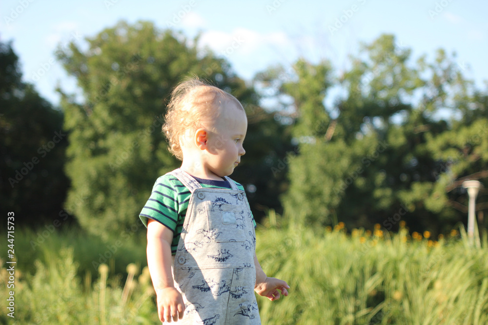 A handsome boy is standig outdoor on the green grass A handsome boy is standig outdoor on the green grass