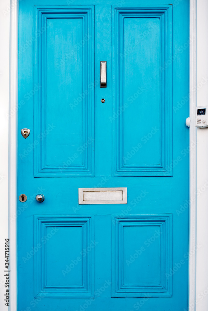 Beautiful blue door with letterbox in a white house facade in Notting Hill Beautiful blue door with letterbox in a white house facade in Notting Hill